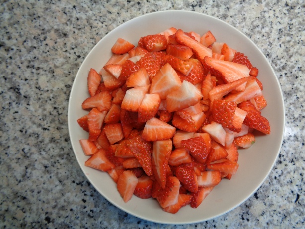 Die Erdbeeren fein schneiden und mit dem Zucker in eine Pfanne geben