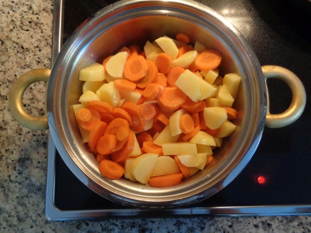 Die Karotten und Kartoffeln zu den Zwiebeln geben