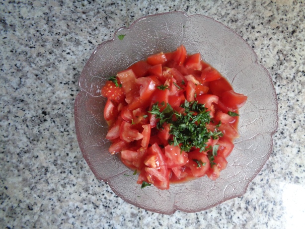 Die Tomaten in Stücke schneiden und mit den restlichen Zutaten vermengen
